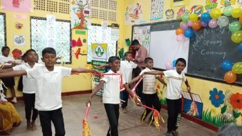 students using math instruments in classroom, primary school learning resources, rural Sri Lankan classroom environment, educational tools for young learners, teachers supporting math activities, classroom name board installation