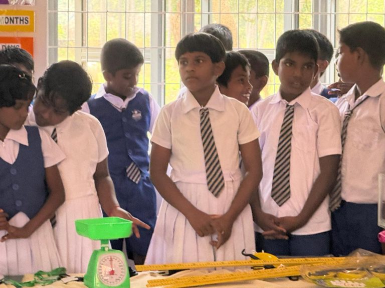Konavil Kanthy Primary School signboard Kilinochchi Sri Lanka, students and teachers gathered during mathematics classroom opening event, children standing together during school program in Kilinochchi, students participating in school education project event Sri Lanka, school community gathered for mathematics classroom opening ceremony, primary school students in uniform attending education initiative, students interacting during mathematics classroom project event, rural Sri Lanka school education support program