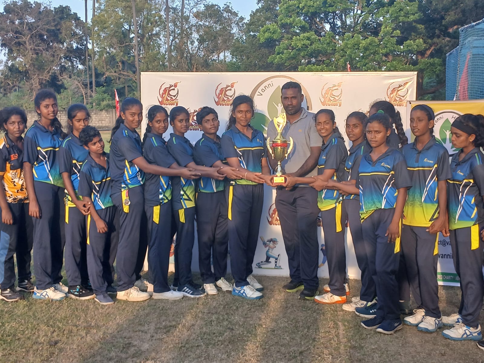 women’s cricket match Jaffna District Cricket Ground Mallakam, female cricket players competing in T20 tournament Sri Lanka, women’s cricket teams in action Jaffna, trophy presentation at women’s cricket event Sri Lanka, players receiving awards and medals cricket tournament, community gathered at women’s sports event Jaffna, cricket match scoring and umpiring setup Sri Lanka, women athletes competing in organized cricket tournament